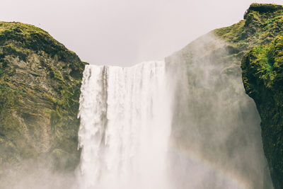 Scenic view of waterfall against sky