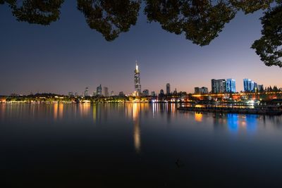 Reflection of buildings in city at waterfront