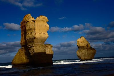 Rock formation on beach against sky