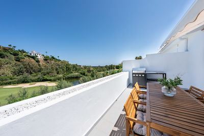 Road amidst buildings against clear blue sky