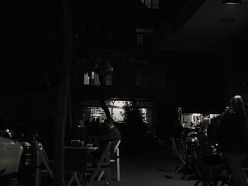 Rear view of people standing in city at night