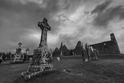 Statue in cemetery against sky