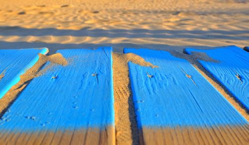 Close-up of wooden plank on sand