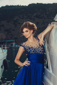 Beautiful young perfect girl in a dress and makeup, summer trip on a yacht with white sails 