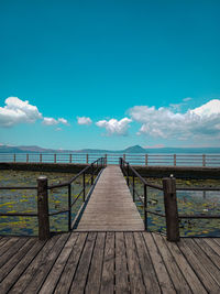 Pier over sea against the blue sky. a clear blue sky makes everyone in a positive mood. 