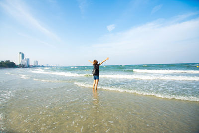 Carefree woman standing on shore at beach