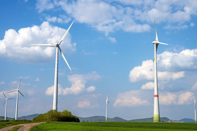 Windmills on field against sky