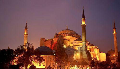 Illuminated buildings in city against sky at night