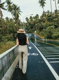 Rear view of woman on palm trees by plants