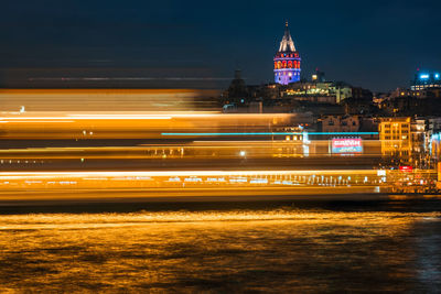 Light trails on illuminated city buildings at night