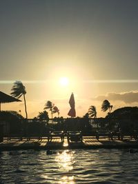 Silhouette boats in sea against sky during sunset