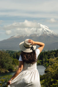 Rear view of woman standing against mountain