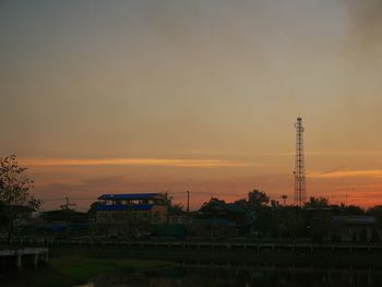 Cranes against sky during sunset