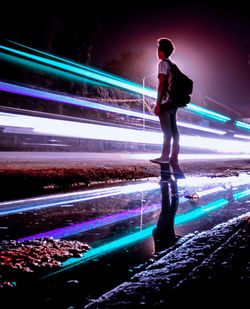 Full length of man standing in illuminated city at night