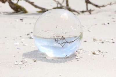 Close-up of crystal ball on sand