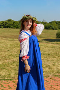 Portrait of smiling young woman standing against on land