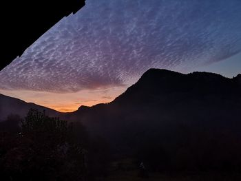 Scenic view of silhouette mountains against sky at sunset