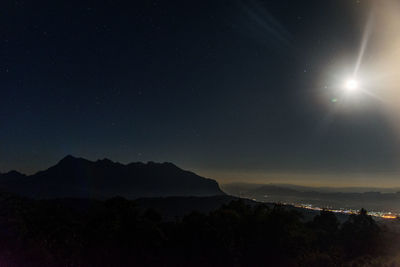 Scenic view of silhouette mountains against sky at night