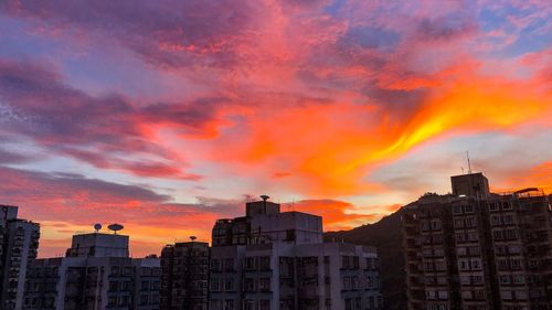 Low angle view of buildings against dramatic sky