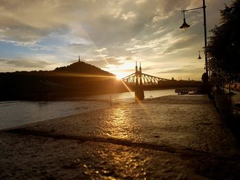 Bridge over river against sky during sunset