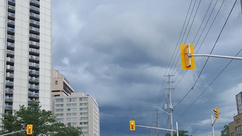 Low angle view of buildings against cloudy sky