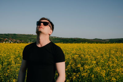 Portrait of woman standing on field against sky