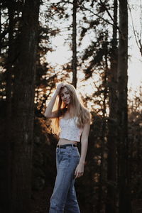 Woman standing by tree in forest