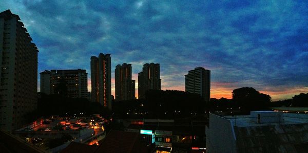 Illuminated cityscape against sky at night