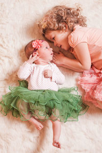 High angle view of siblings lying on bed at home