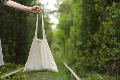 Midsection of woman holding bag outdoors