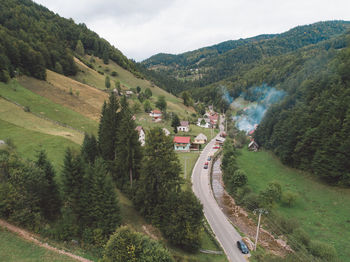 High angle view of road amidst trees against sky