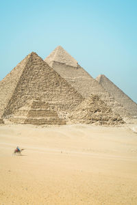 Pyramids on desert against clear sky