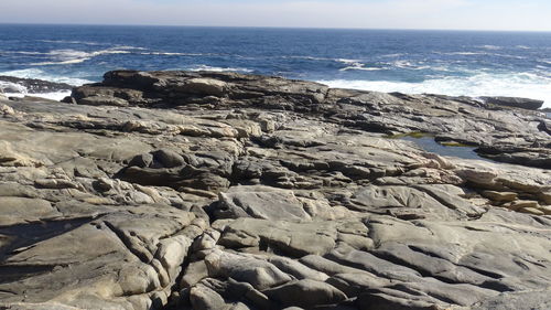 Scenic view of rocks on beach against sky