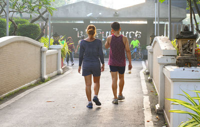 Rear view of people walking on footpath
