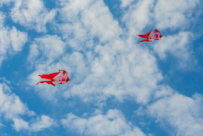 Low angle view of red flag against sky