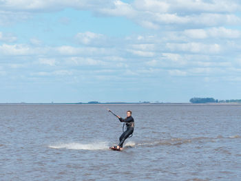 Man in sea against sky