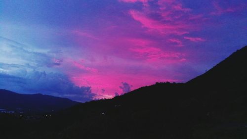 Low angle view of silhouette mountains against dramatic sky