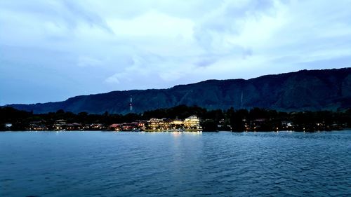 Scenic view of sea by buildings against sky