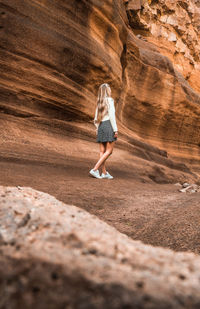 Rear view of woman walking on rock
