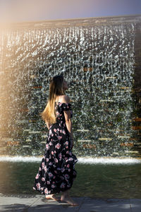 Woman photographing at camera against sky