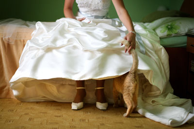 Low section of woman sitting on bed