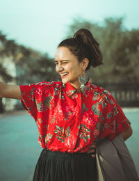 Smiling young woman standing outdoors