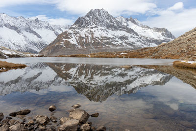 Winter landscape reflected in calm lake. snow covered mountain olmenhorn reflected in maerjelensee.