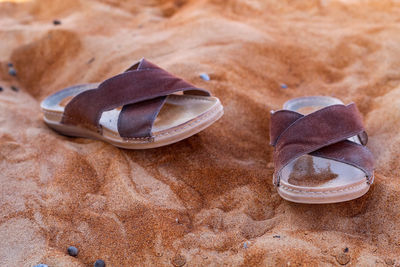 Close-up of shoes on the sand