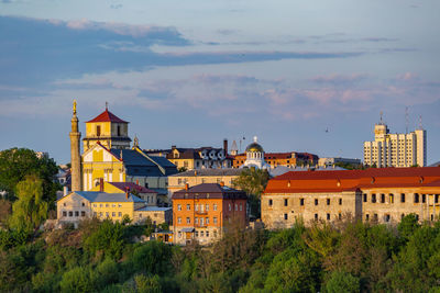 View of buildings in city against cloudy sky