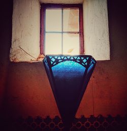 Close-up of illuminated lamp against wall