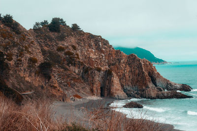 Rock formations by sea against sky