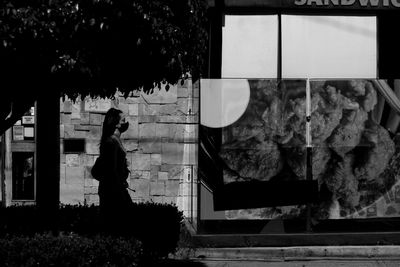 Side view of woman standing by plants