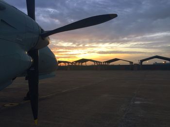 Silhouette airplane wing against sky during sunset