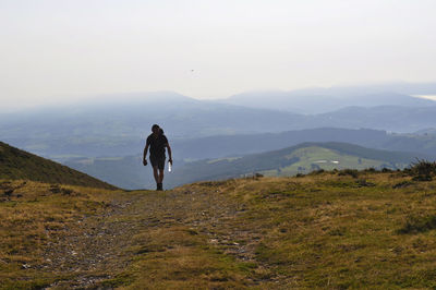 Rear view of men on landscape against mountains